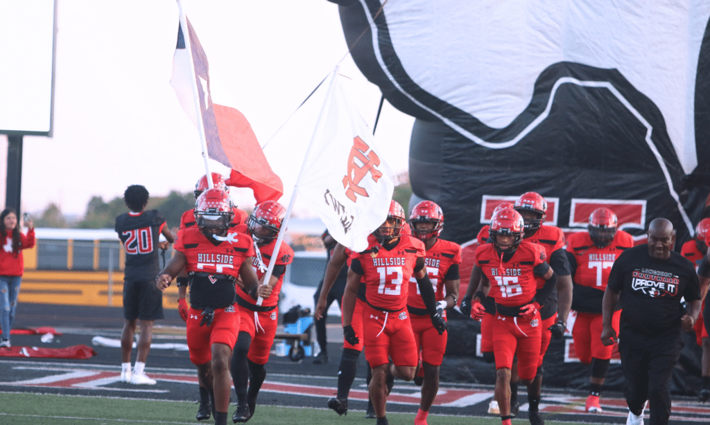Football team in read uniforms running onto the field